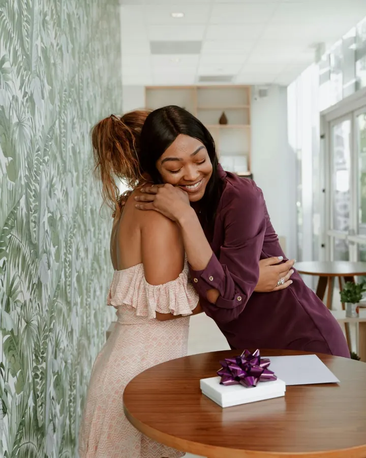 Two friends hugging over a gift