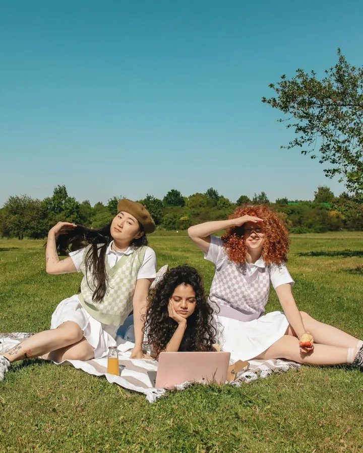 Three friends relaxing on a picnic blanket