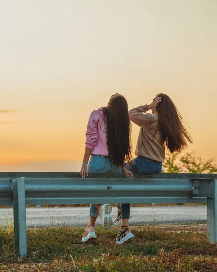 Two friends watching the sunset together